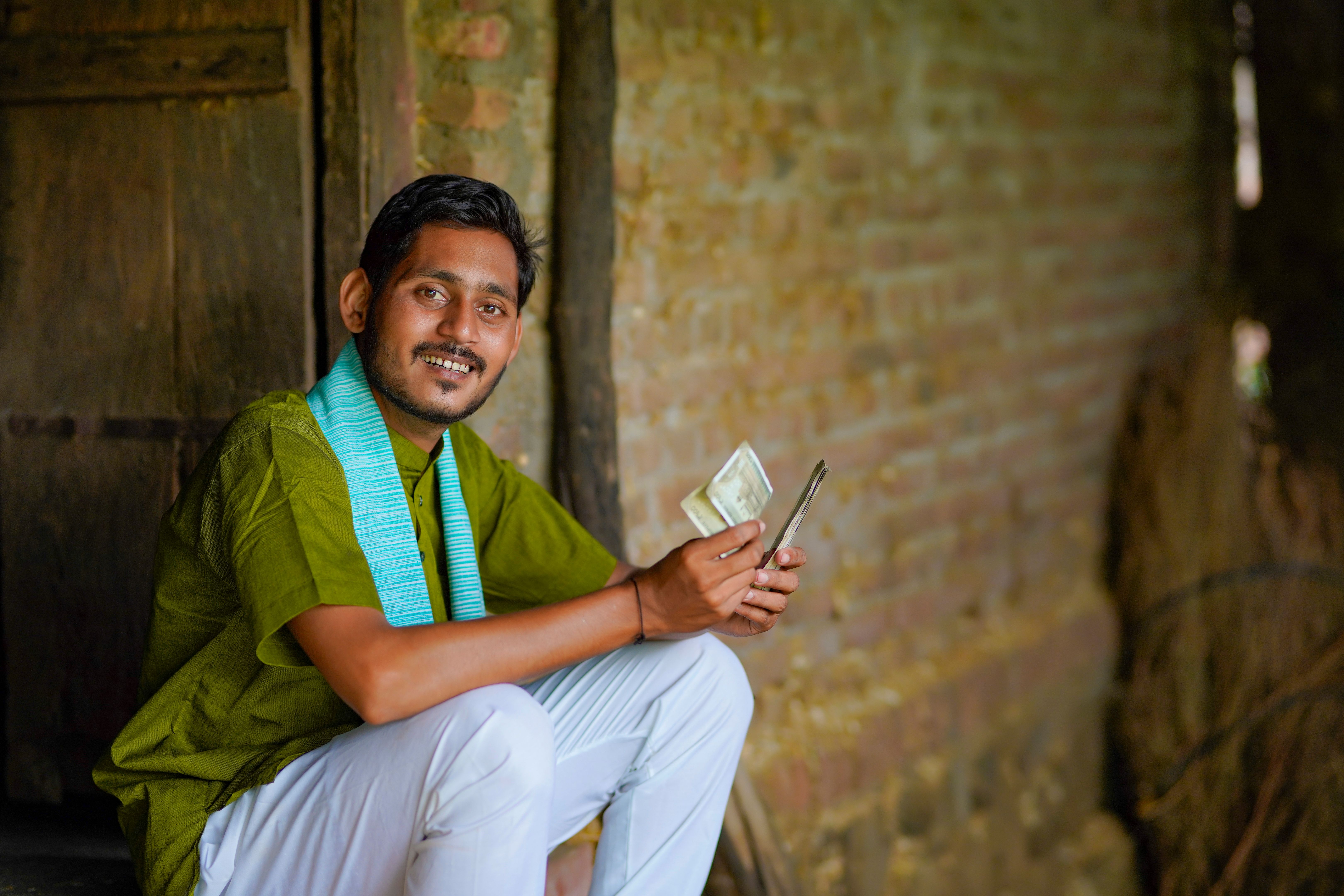 Indian farmer or labor counting money at home.